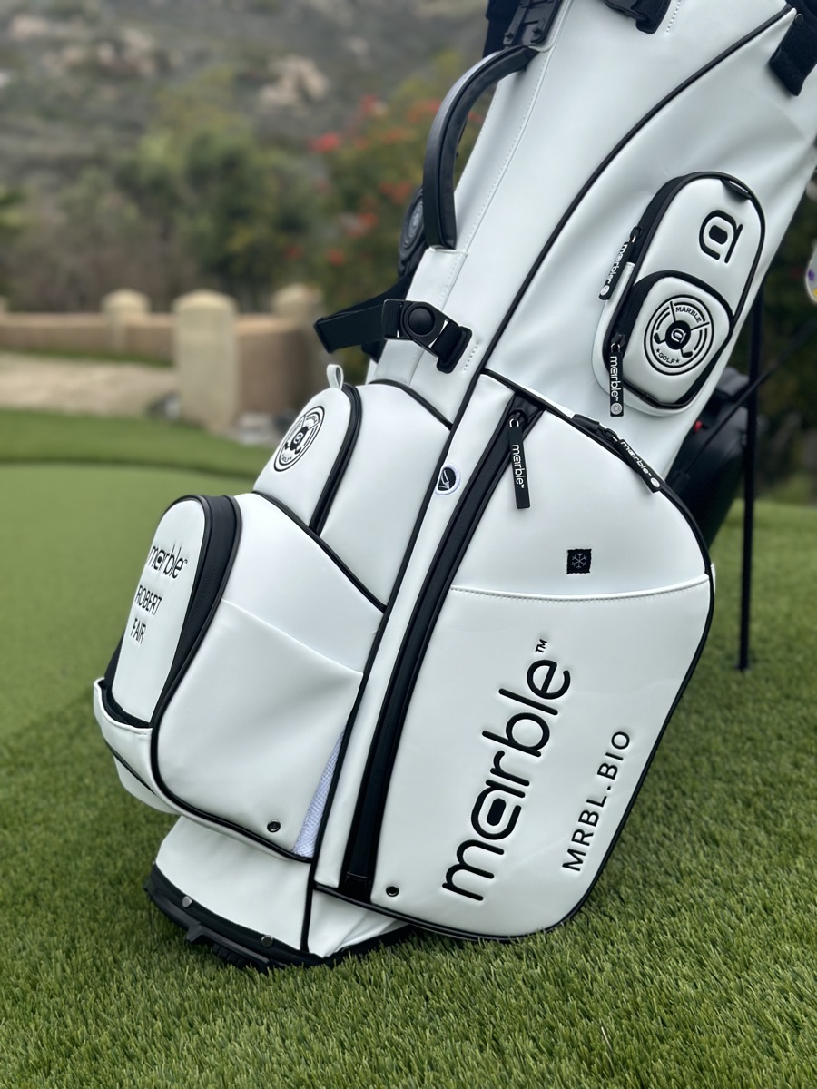Close low-angle view of the bag's white leather body and embossed marble wordmark