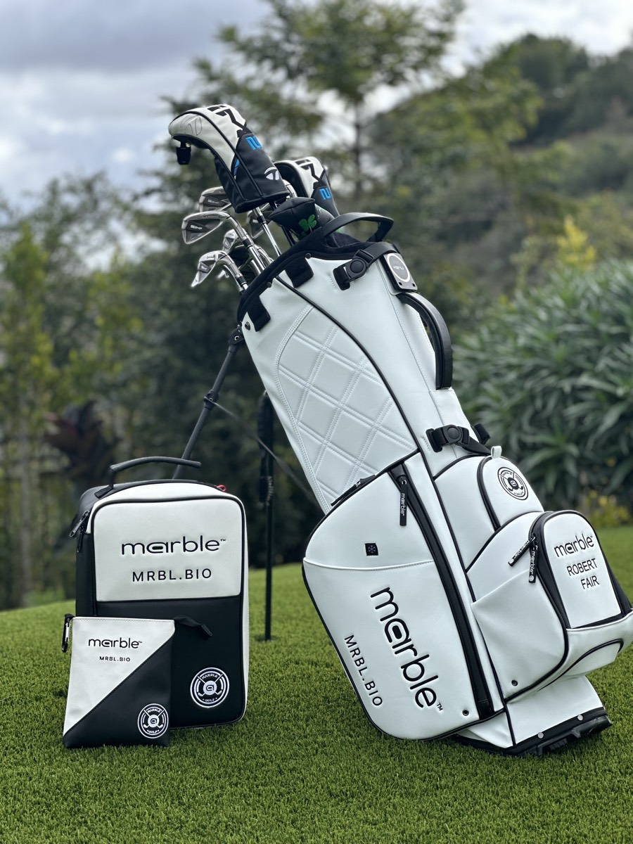 Low-angle view of the bag's diamond-quilted white leather, black handle and metal zipper pulls